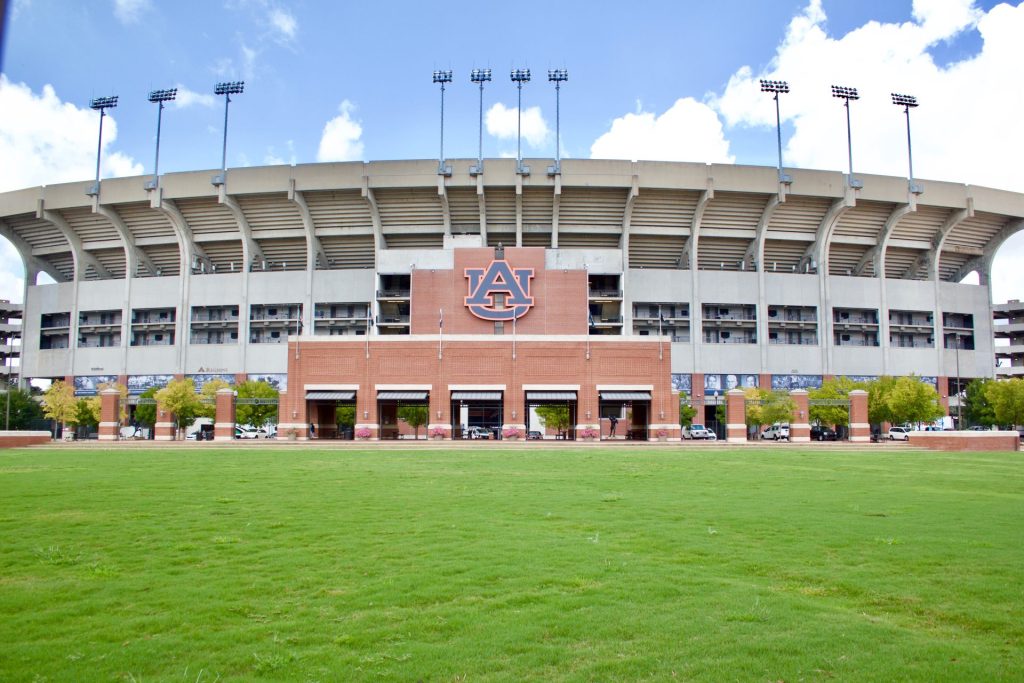 Exterior view of Auburn University's stadium in Auburn, AL, featuring green lawn and blue sky. Our construction company in Auburn, Alabama is JLD Enterprises.