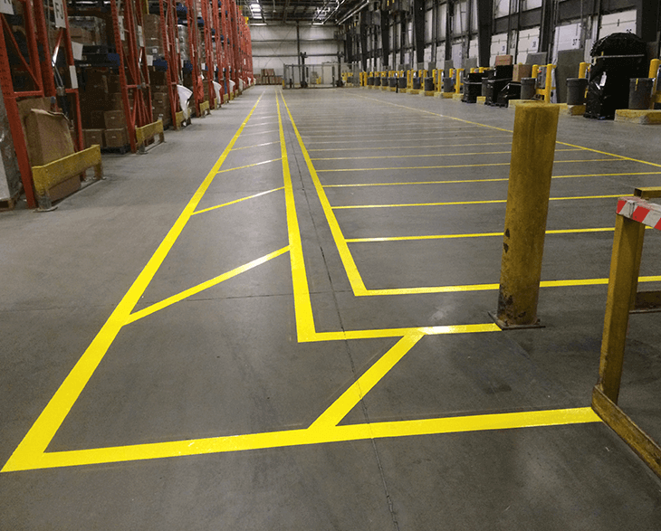 Warehouse floor with yellow safety lines in Auburn, AL, highlighting organized storage areas and pathways.